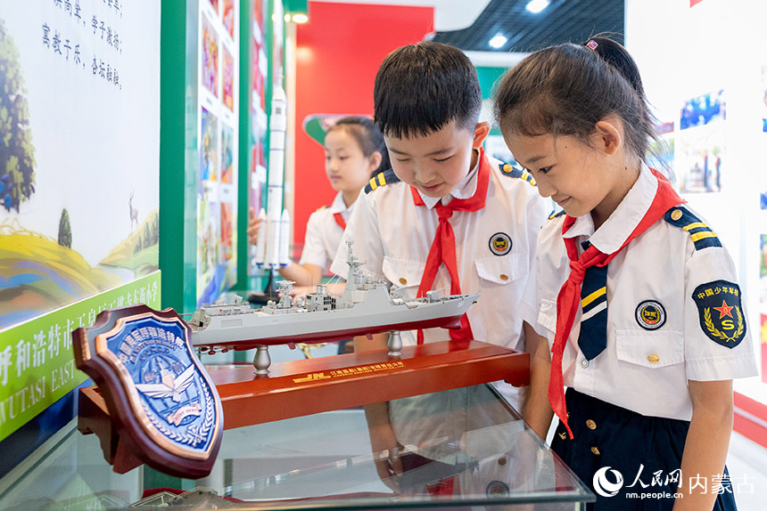 呼和浩特市玉泉区五塔寺东街小学少年军校学生在学校国防教育展厅观看军舰模型。丁根厚摄