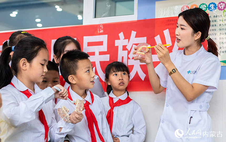 口腔医生在呼和浩特市玉泉区公义店小学对学生进行口腔防治知识宣传教育。丁根厚摄