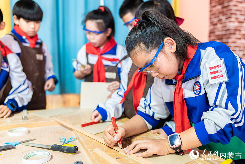 呼和浩特市玉泉区通顺街小学学生在学习体验木工制作技艺。丁根厚摄