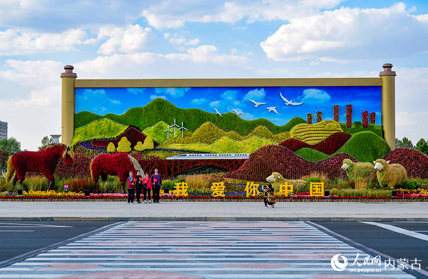 游客在鄂爾多斯市康巴什區“祝福祖國 喜迎二十大”主題花壇前拍照留念。王正攝