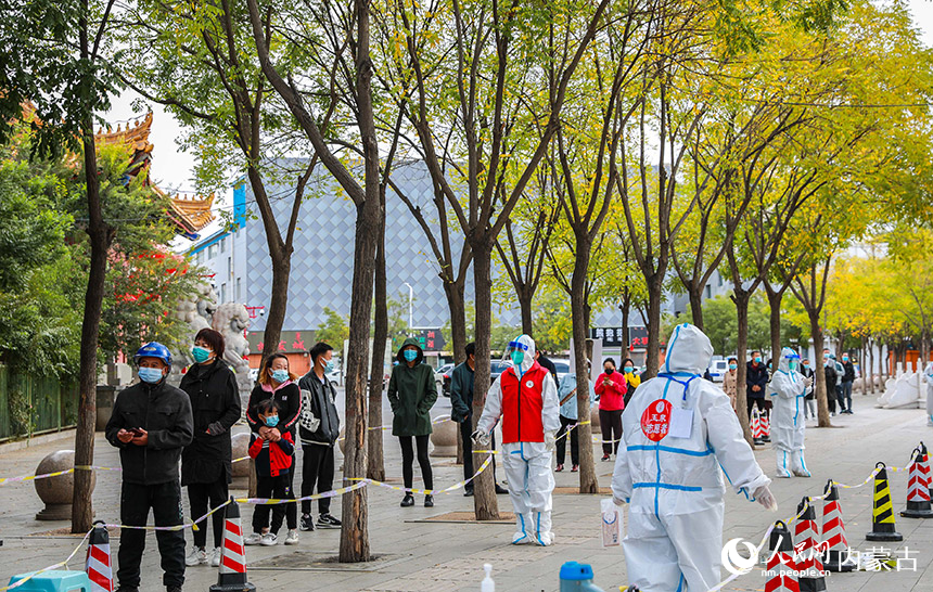 呼和浩特市玉泉區一處核酸篩查點，黨員志願者對核酸採樣通道進行消殺。丁根厚攝