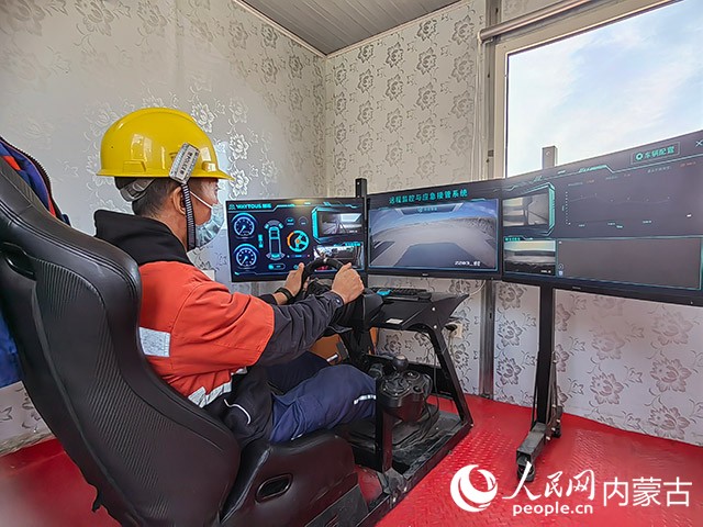 包长明正在远程操控矿卡车。人民网 刘艺琳摄