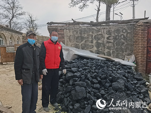 八龙湾村党员志愿者和驻村工作队员帮助刘占宽家整理领到“暖心煤”。八龙湾村供图