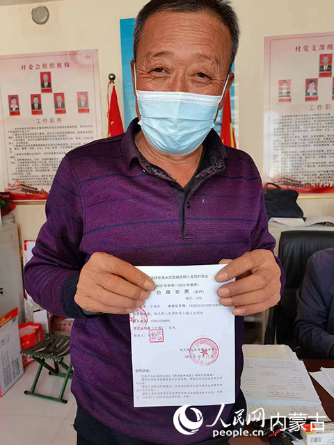 村干部胡俊文为村民领取煤票。清水河县组织部供图