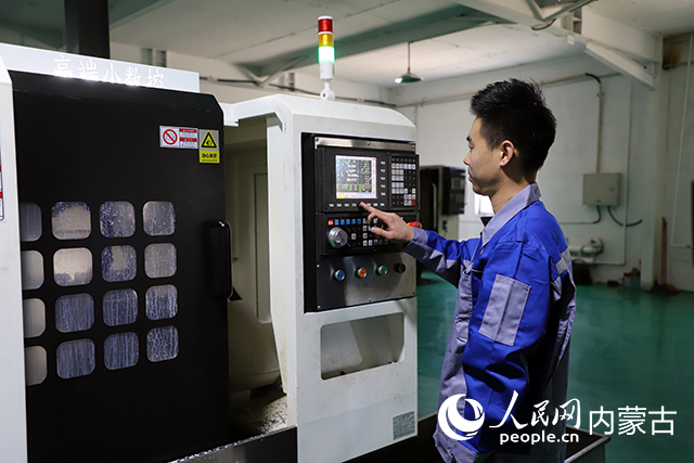 工厂工人操作机械。突泉县融媒体中心供图