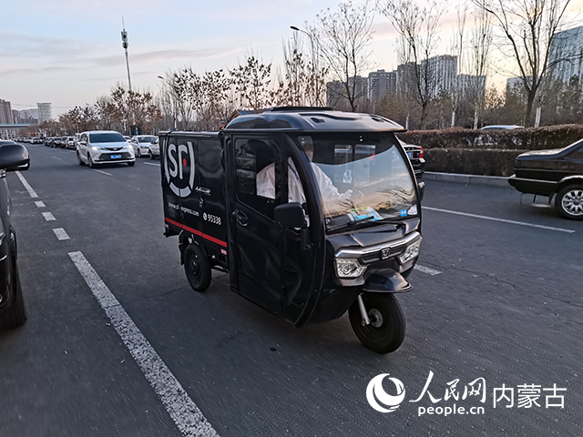 11月22日，顺丰快递员正在呼和浩特市街头派送快件。