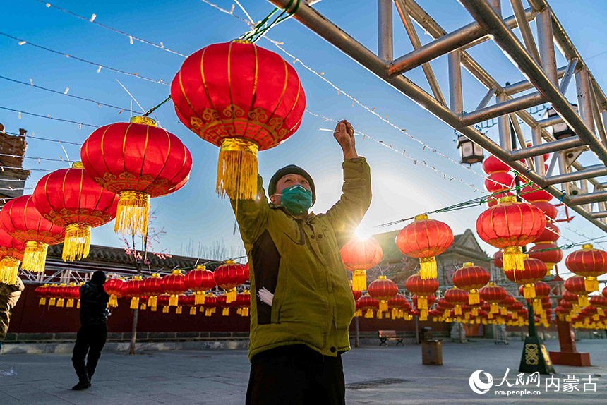 工作人员在内蒙古呼和浩特市玉泉区塞上老街步行街安装悬挂红灯笼。丁根厚摄