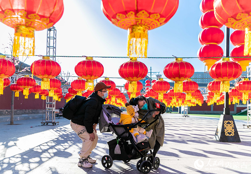 市民在内蒙古呼和浩特市玉泉区塞上老街步行街的灯笼长廊下“打卡”留影。丁根厚摄