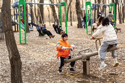 在改造后的包头市公园儿童区里玩耍的儿童。