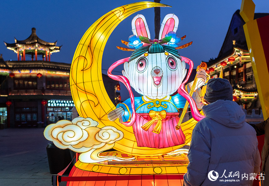 1月18日晚，游客在呼和浩特市玉泉区塞上老街历史文化街区观赏“福兔迎春”花灯。丁根厚摄