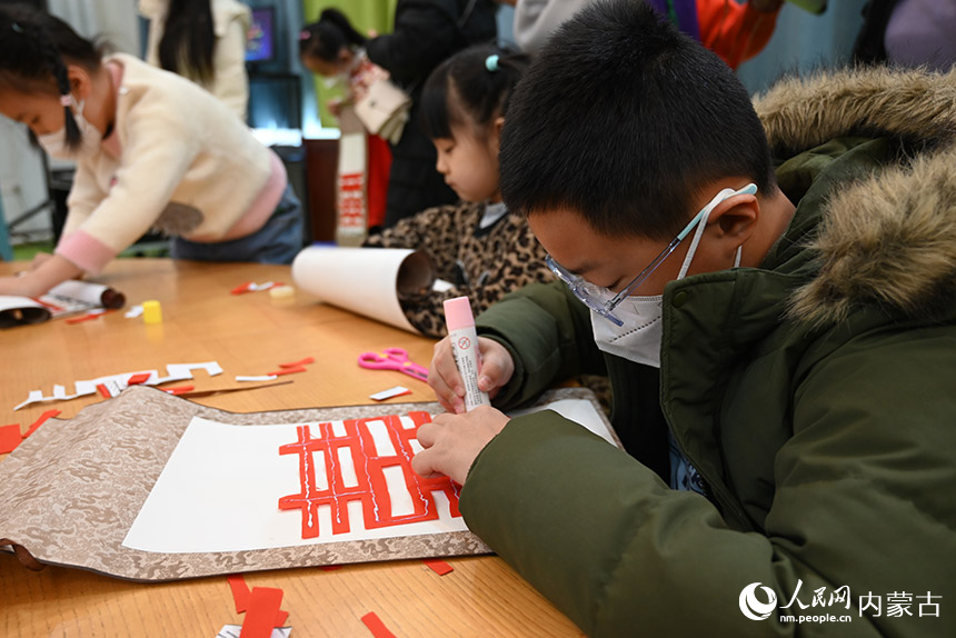 活动现场，小朋友正在剪纸。人民网 刘艺琳摄