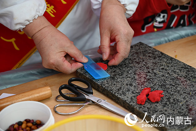 內蒙古莜面制作技藝傳承人現場演示並介紹莜面的各種制作方法。人民網 劉藝琳攝