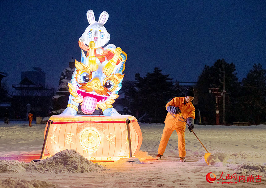 2月9日，呼和浩特市玉泉环境卫生服务中心的环卫工人在塞上老街历史文化街区清扫积雪。丁根厚摄