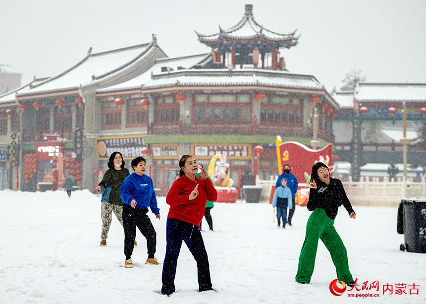 2月9日，市民在呼和浩特市玉泉区塞上老街历史文化街区的雪地里跳广场舞。丁根厚摄