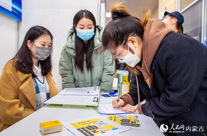 2月11日,呼和浩特市玉泉区用工综合服务中心,求职者在招聘会上向用工企业登记报名。丁根厚摄
