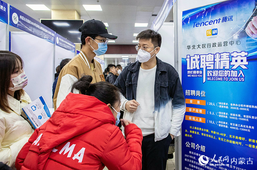 2月11日,呼和浩特市玉泉区用工综合服务中心,求者在招聘会上了解用工信息。丁根厚摄
