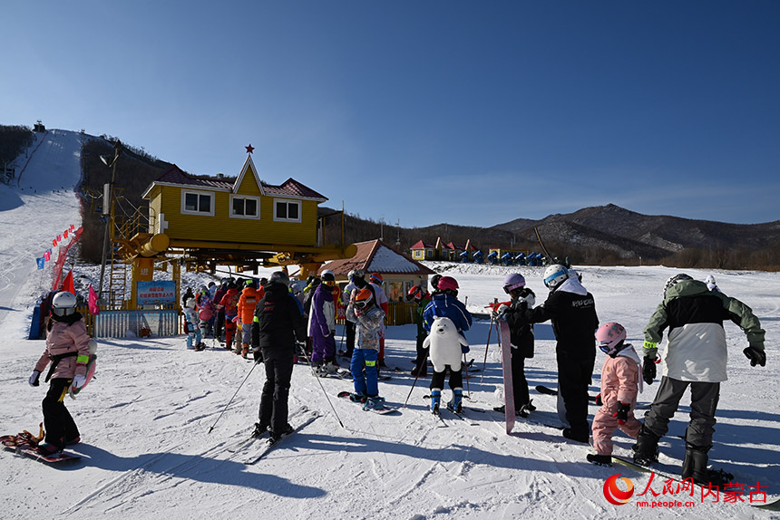 金龙山滑雪场内，滑雪爱好者排队上缆车。人民网 刘艺琳摄