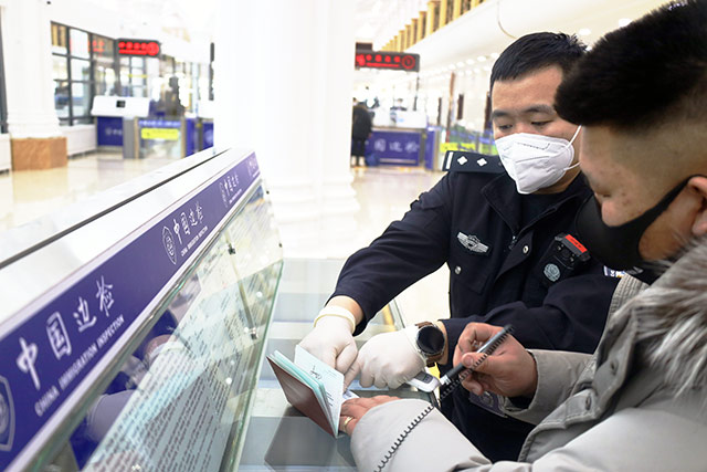執勤民警幫助入境旅客填寫信息採集卡。