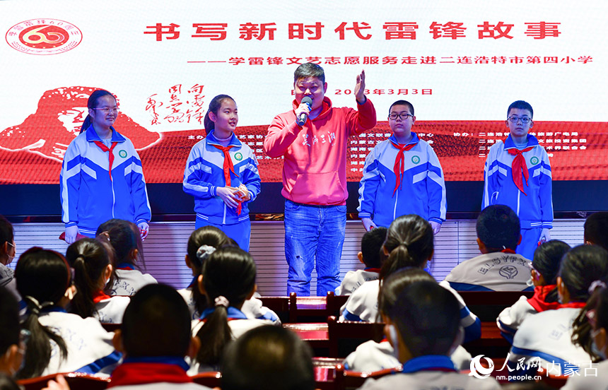 3月3日，在二连浩特市第四小学，文艺志愿者杨文辉为喜爱说唱艺术的学生传授表演技艺。王正摄