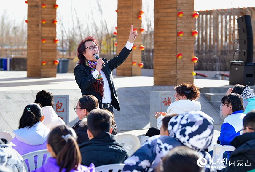 3月3日，在二连浩特市格日勒敖都苏木赛乌素嘎查文化广场，一位文艺志愿者为群众演唱歌曲《珊瑚颂》。王正摄