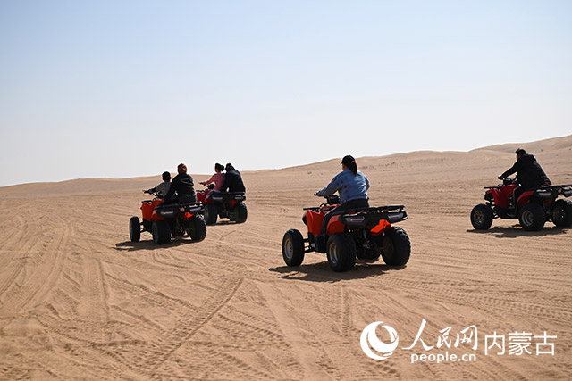 游客骑着沙漠摩托车在沙海中驰骋。人民网 寇雅楠摄