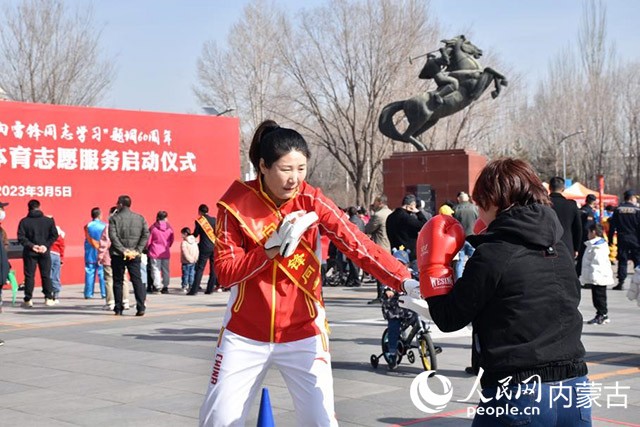运动员杨晓丽指导市民进行拳击运动。实习生拓宇婷摄