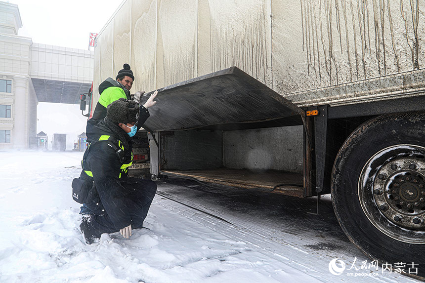 满洲里边检站民警顶风冒雪执行货车监护任务。李发春摄