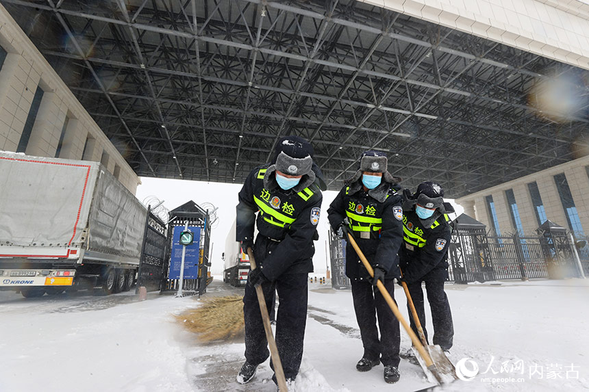 满洲里边检站民警清理通道积雪，保障货车通行。卢兵兵摄
