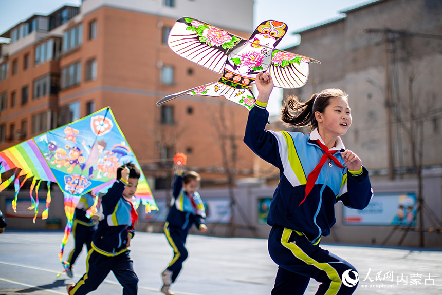 3月20日，内蒙古呼和浩特市玉泉区恒昌店巷小学学生在放飞风筝。丁根厚摄