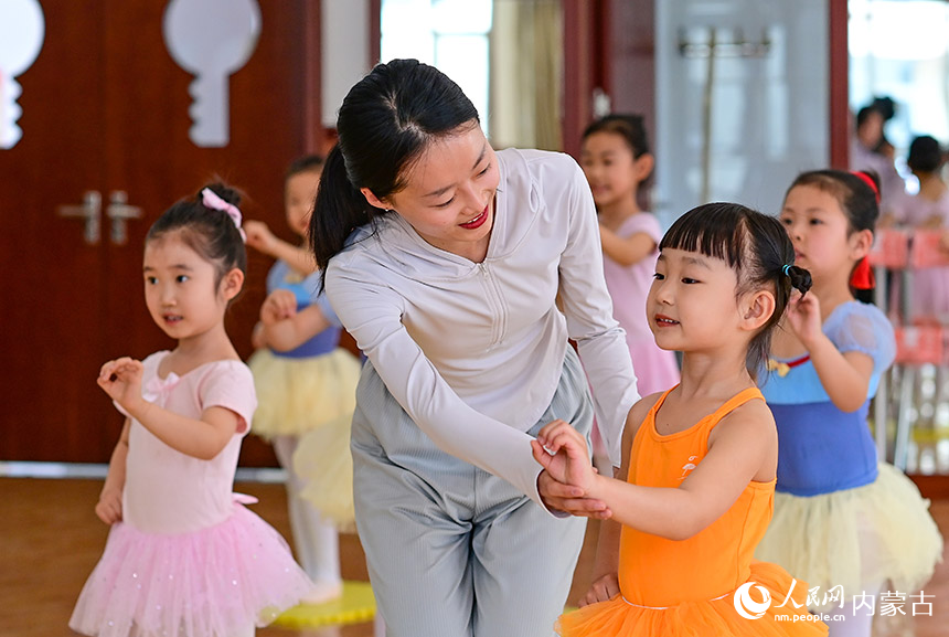 呼和浩特市赛罕区第八幼儿园教师指导小朋友学习舞蹈。王正摄