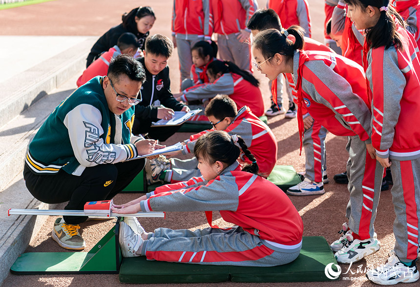 呼和浩特市玉泉区通顺街小学学生在进行坐位体前屈项目的测试。丁根厚摄