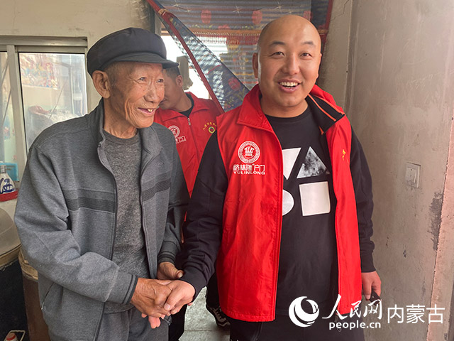 吳建成（右）慰問老人。受訪者供圖