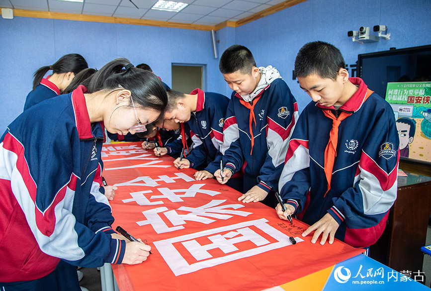 4月12日，内蒙古呼和浩特市第二十六中学学生在“国家安全 人人有责”宣传条幅上签名。丁根厚摄