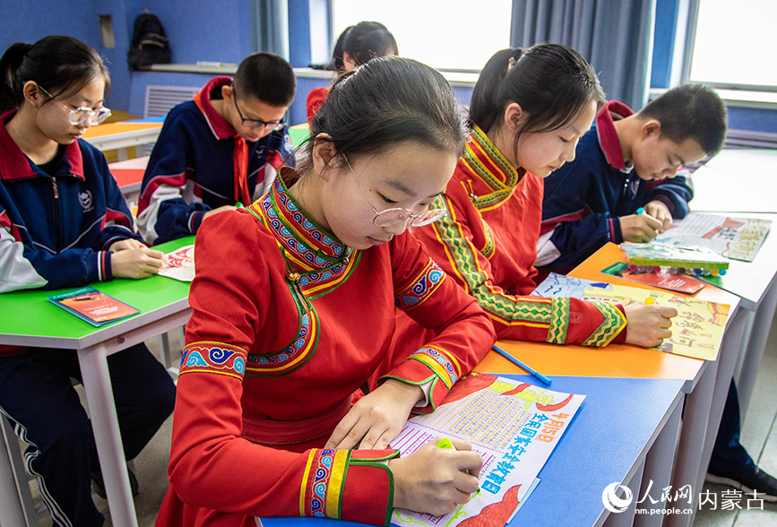 4月12日，内蒙古呼和浩特市第二十六中学学生在绘制国家安全教育主题手抄报。丁根厚摄