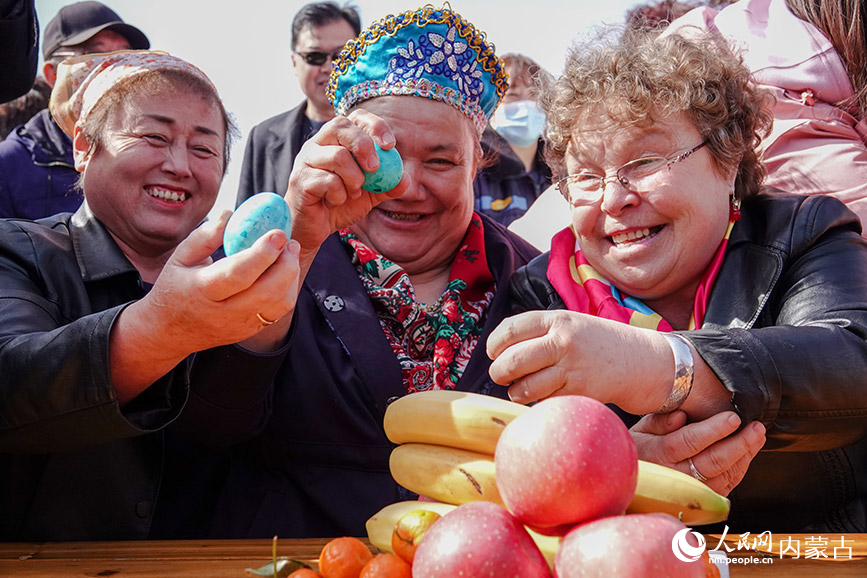 俄罗斯族群众互撞彩蛋，相互祝福。吕昊俊摄