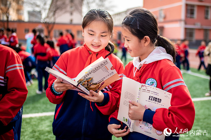4月17日，内蒙古呼和浩特市玉泉区南茶坊小学学生在“图书漂流”集市上交流读书心得。丁根厚摄