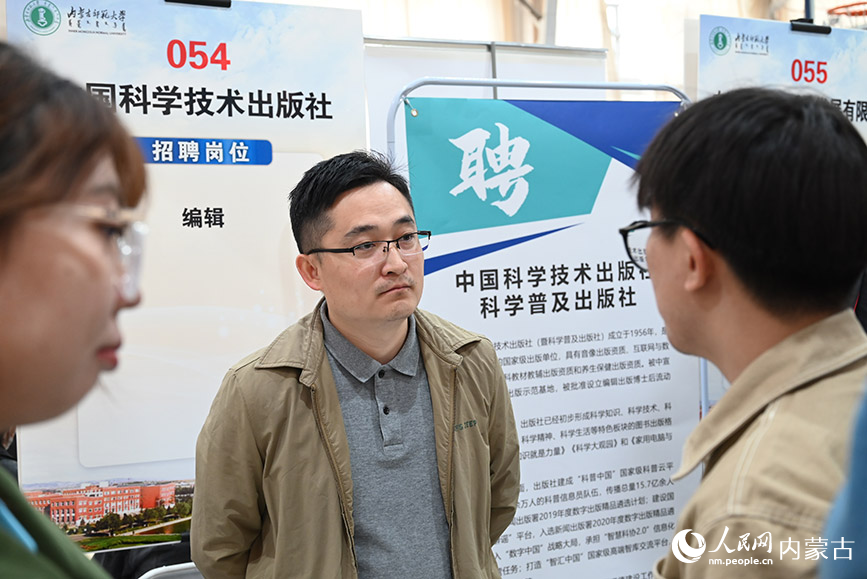 招聘人员与求职者交流岗位信息。人民网 刘艺琳摄