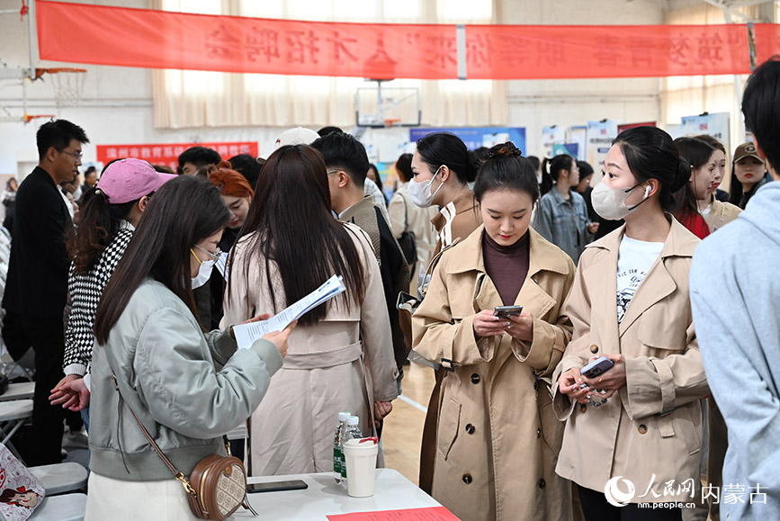 求职者在招聘会上了解就业信息。人民网 刘艺琳摄