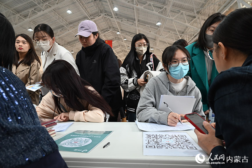 招聘人员与求职者交流岗位信息。人民网 刘艺琳摄