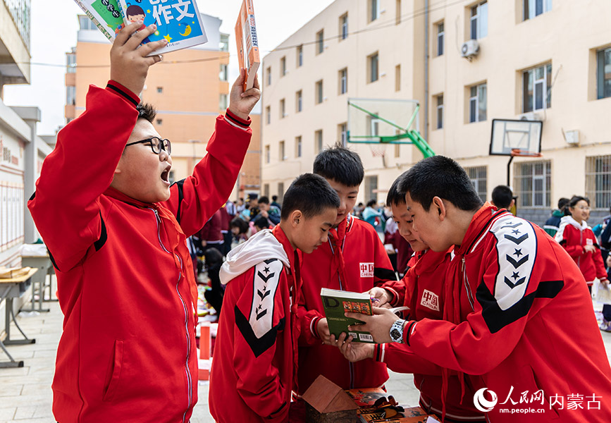 4月21日，呼和浩特市玉泉区恒昌店巷小学学生在“跳蚤市场”上吆喝招揽顾客。丁根厚摄