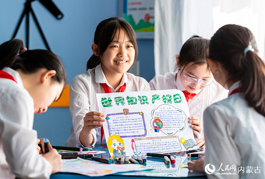 呼和浩特市玉泉区恒昌店巷小学学生向小伙伴展示以“世界知识产权日”为主题的手抄报。丁根厚摄