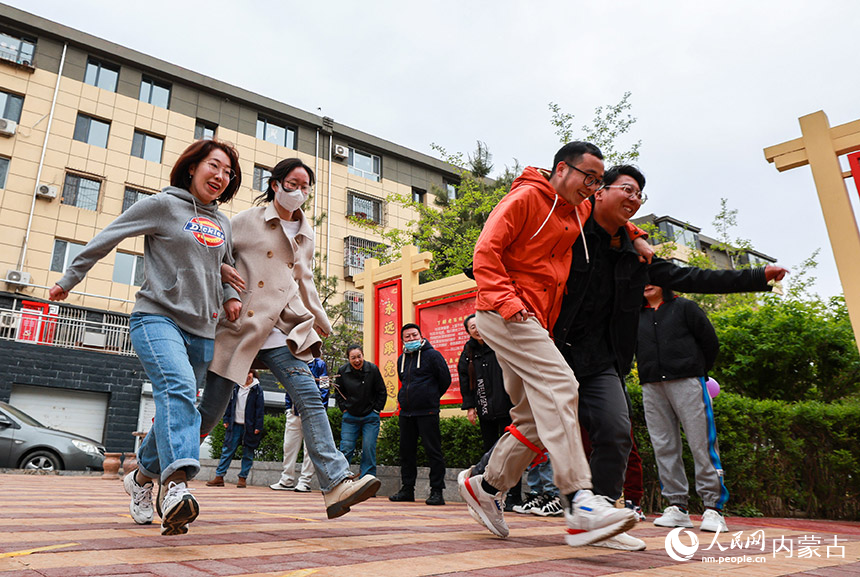 呼和浩特市玉泉区清泉街社区的干部群众在进行“两人三足”比赛。丁根厚摄