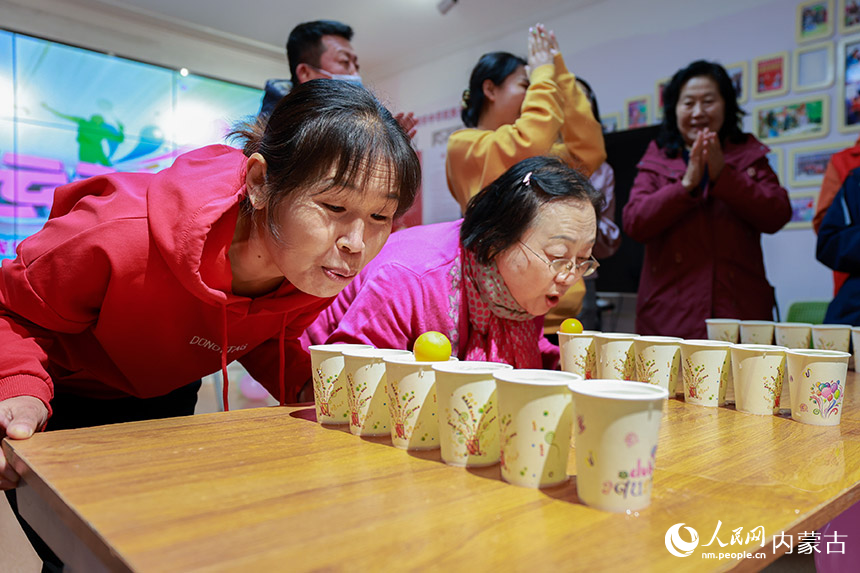 呼和浩特市玉泉区清泉街社区的干部群众在进行“水上运球”比赛。丁根厚摄