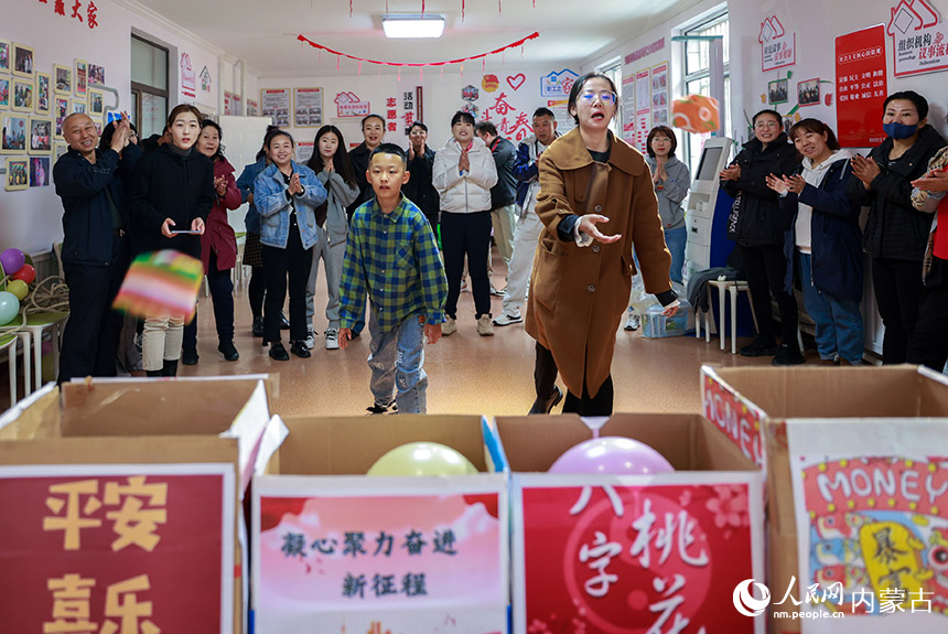 呼和浩特市玉泉区清泉街社区的干部群众在进行投沙包比赛。丁根厚摄