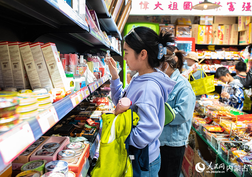 4月30日，游客在呼和浩特市玉泉区塞上老街区块夜市“童年杂货铺”选购商品。丁根厚摄