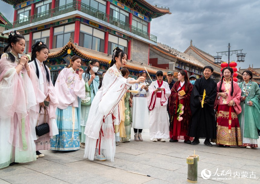 5月1日，华服爱好者在呼和浩特市玉泉区塞上老街参加投壶游戏。丁根厚摄