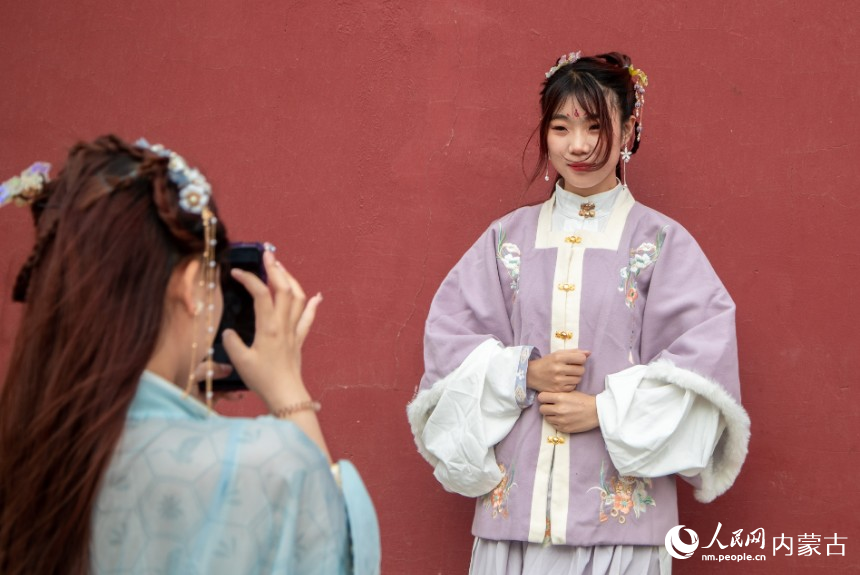 5月1日，华服爱好者在呼和浩特市玉泉区塞上老街华服巡游活动现场拍照打卡。丁根厚摄