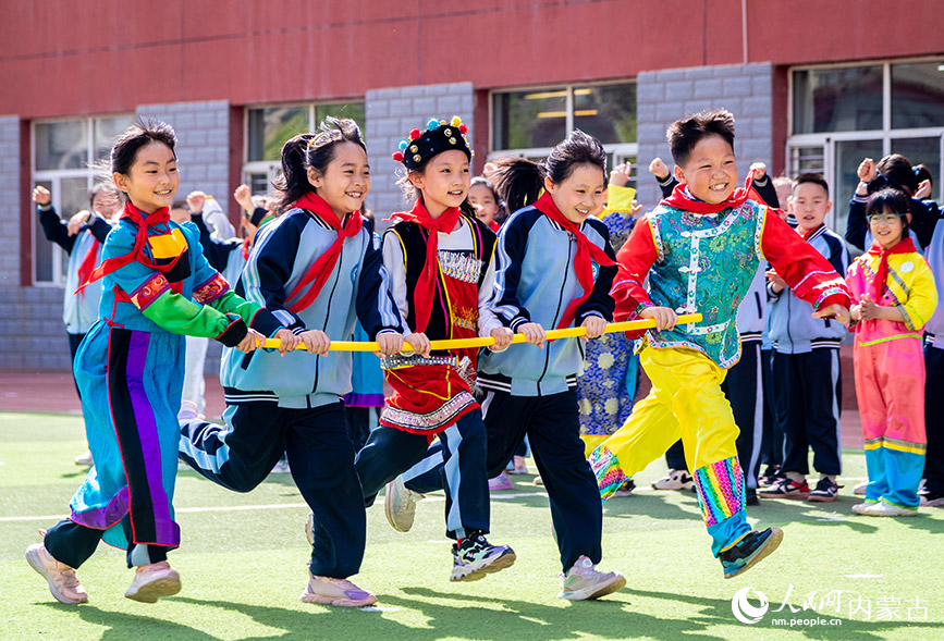 5月8日，呼和浩特市玉泉区南柴火市街小学学生在参加五人绕桩趣跑比赛。丁根厚摄