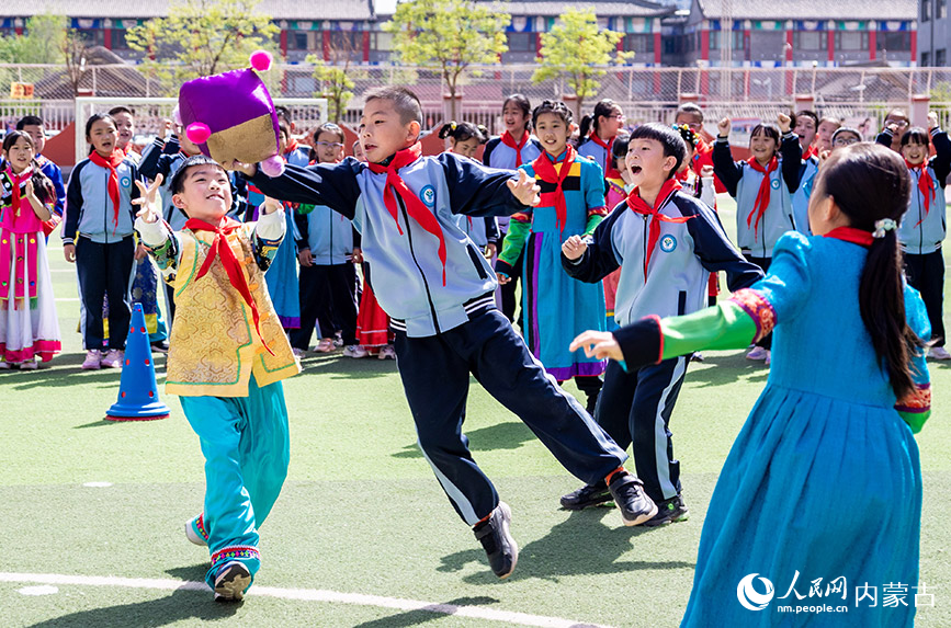 5月8日，呼和浩特市玉泉区南柴火市街小学学生在参加抢沙包比赛。丁根厚摄
