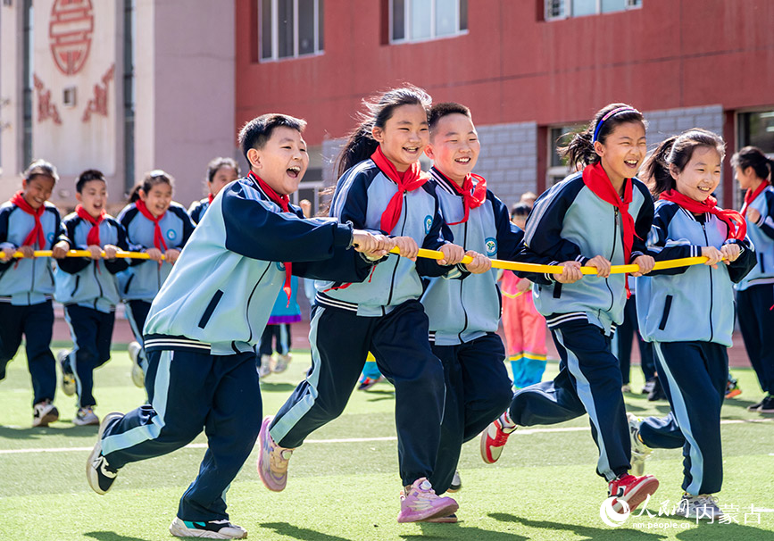 5月8日，呼和浩特市玉泉区南柴火市街小学学生在参加五人绕桩趣跑比赛。丁根厚摄